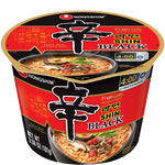 Nong Shim Shin Ramyun Black noodle soup package with steaming bowl of spicy instant ramen on a table