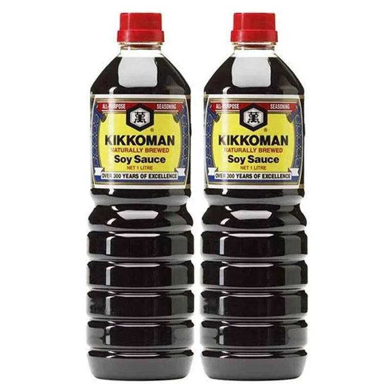 Two 1-liter bottles of Kikkoman soy sauce in clear plastic containers, showing the Kikkoman branding and dark soy sauce inside.