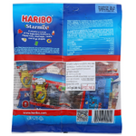 Colorful assortment of Haribo Starmix confectionery snacks with gummy bears, frogs, and other chewy candies on a white background.