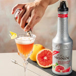 Monin Red Grapefruit Fruit Mix in 1000ml bottle, dry grocery, vibrant red grapefruit flavor for cocktails and beverages.