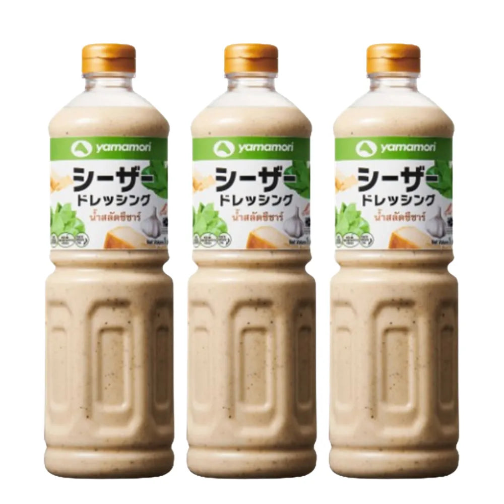 Yamamori Caesar Salad Dressing 1L bottles, three-pack, in clear bottles with yellow labels, displayed on a kitchen counter.