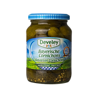 Develey Bavarian Cornichons in a jar, small pickled cucumbers with a crunchy texture and tangy flavor, on a grocery shelf.