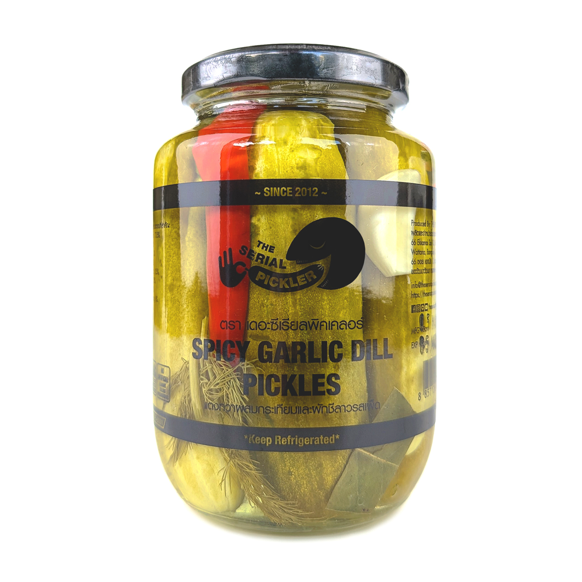 Jar of The Serial Pickler Spicy Garlic Dill Pickles with sliced garlic and dill visible in the brine, on a wooden surface.