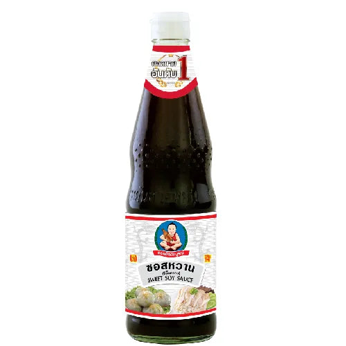 Deksomboon Sweet Soy Sauce 950g bottle, side view showing the dark liquid inside a clear plastic container for dry grocery use