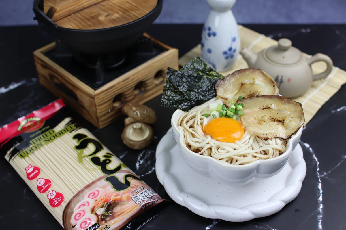 Dried Rabbit Brand Udon Noodles shown in a clear package, ready for cooking, with thick wheat noodles visible inside.
