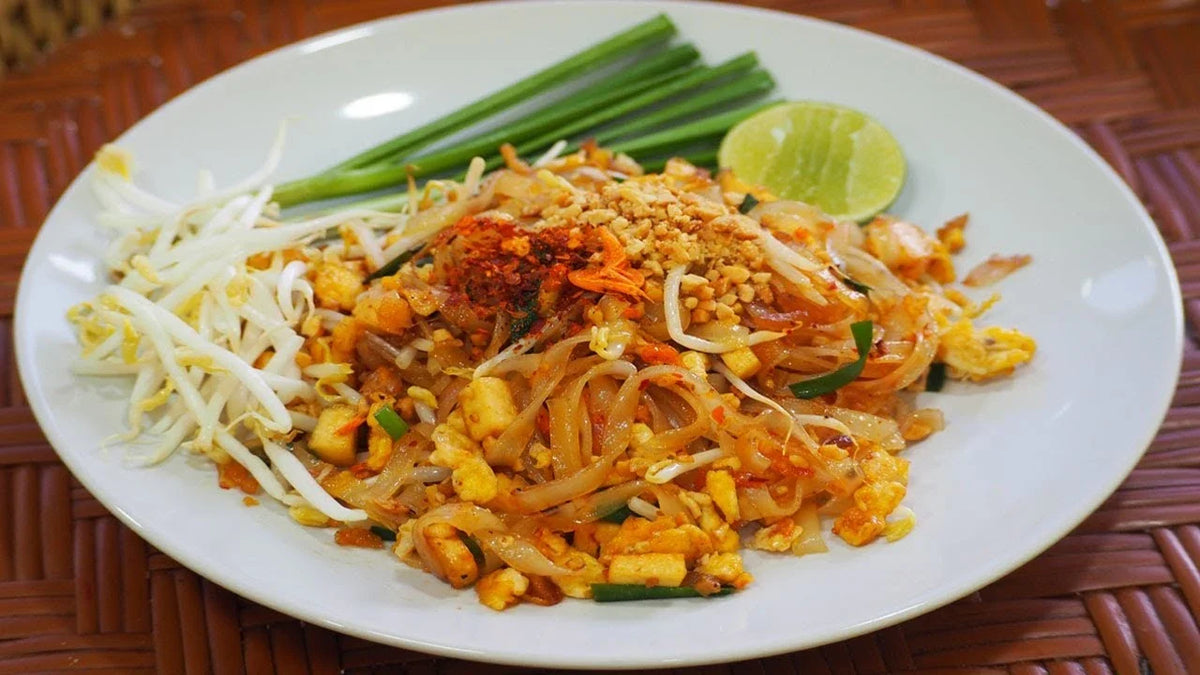 J-LEK Pad Thai Sauce bottles, 1150g, in clear plastic bottles with orange caps, ideal for authentic Thai cooking.