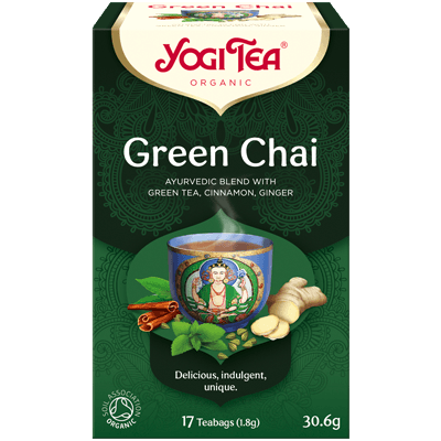 A cup of Yogi Green Chai herbal tea in a clear glass, showing the vibrant green tea leaves and brewed beverage inside.