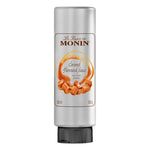 Bottle of MONIN caramel sauce in 500ml bottle, featuring rich caramel color and label, suitable for desserts and coffee.