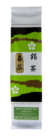 Ban Cha tea drink in a clear glass, showcasing its light amber color with fresh tea leaves and a straw for drinking.