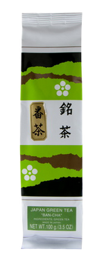 Ban Cha tea drink in a clear glass, showcasing its light amber color with fresh tea leaves and a straw for drinking.