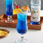 Bottle of MONIN Blue Curacao Syrup in a 700ml bottle, used for cocktails and beverages in dry grocery products.