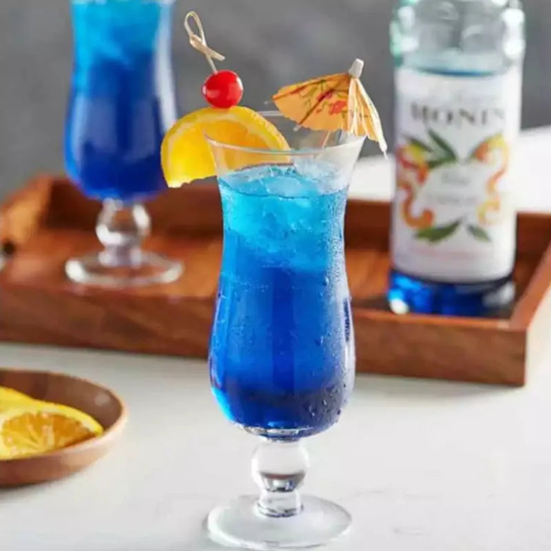 Bottle of MONIN Blue Curacao Syrup in a 700ml bottle, used for cocktails and beverages in dry grocery products.