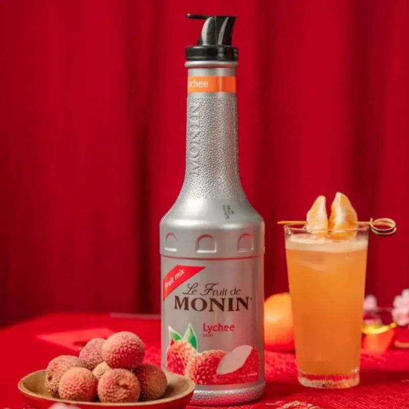 Monin Lychee Fruit Mix 1000ml bottle for cocktails and beverages, showcasing the clear, vibrant liquid in the bottle.